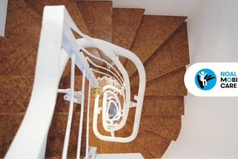 Montascale per scale strette, con gradini in marrone e corrimano bianco. Soluzione ideale per la mobilità in spazi ridotti.
