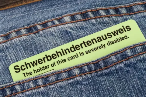 Schwerbehindertenausweis in Jeans-Tasche. Der Ausweis bestätigt den Grad der Behinderung, z.B. bei Herzschrittmacher-Trägern.