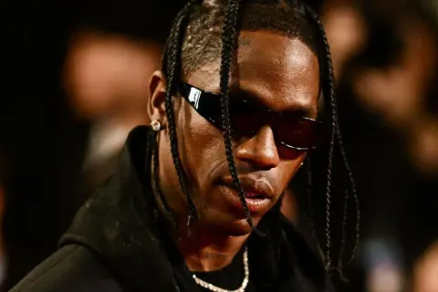 Travis Scott w okularach przeciwsłonecznych, z warkoczykami. Fani w Polsce czekają na jego koncert.