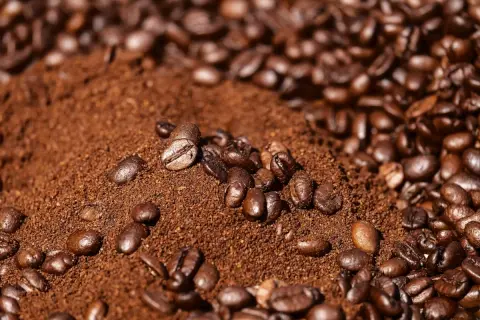 Montón de café molido con granos enteros esparcidos. Parece que el café se pone malo, perdiendo su frescura.