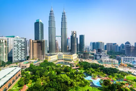Piękna pogoda w Malezji! Wieżowce Petronas i zieleń parku miejskiego w Kuala Lumpur.