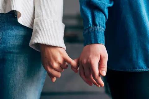 Due mani si stringono con il mignolo, simbolo di un legame che si rinnova dopo un periodo di **lasciarsi e riprendersi psicologia**.