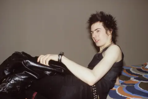Sid Vicious, ikona zespołu Sex Pistols, w skórzanej kurtce i z charakterystyczną fryzurą.