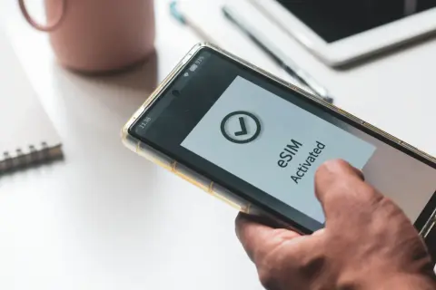 Smartfon z komunikatem "eSIM Activated" na ekranie. Dowiedz się, jak przenieść esim na inny telefon.