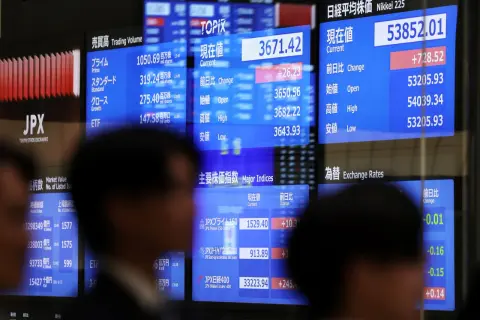 JPX, japoński rynek akcji, pokazuje dane z giełdy. Widoczne są indeksy Nikkei 225 i TOPIX, a także dane o wolumenie obrotu.