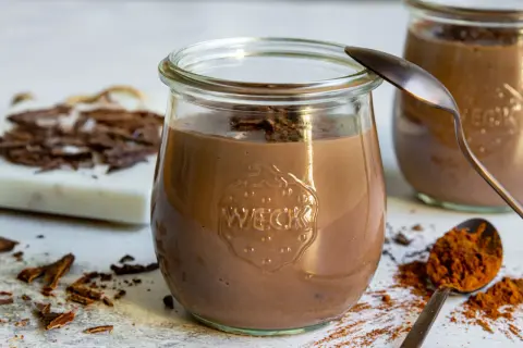 Cremiger Schokopudding, perfekt zum schokopudding selber machen. Serviert in einem Weckglas, garniert mit Schokostückchen.