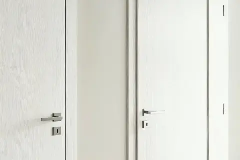Dwie białe drzwi: jedna z widocznym frezem (przylgowe), druga gładka (bezprzylgowe). Eleganckie uchwyty.