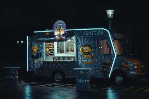 Food truck "Zatachitas" nocą, z neonami i zabawnymi grafikami. Idealny pomysł na dofinansowanie na food trucka!
