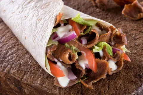 Domowy kebab w tortilli z mięsem, warzywami i sosem. Prosty przepis na to, jak zrobić kebab w domu.