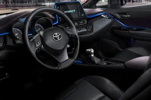 Interiör i en Toyota C-HR Hybrid. En del tycker att den blå accentbelysningen är en charmig detalj, andra ser det som ett potentiellt toyota chr problem.