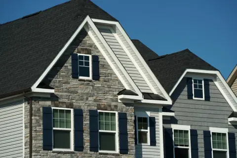 Modern homes with dark asphalt shingles, showcasing their durability and aesthetic appeal.