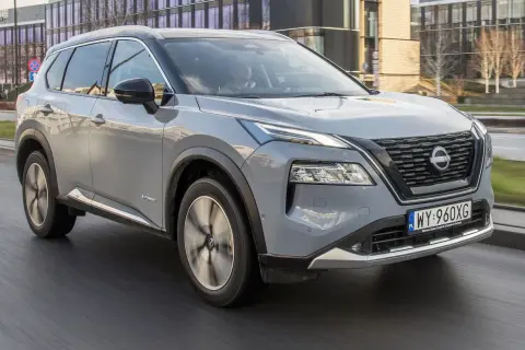 Szary Nissan X-Trail e-POWER w ruchu miejskim. Kierowca testuje jego niskie spalanie.
