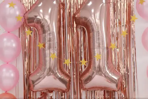 Globos rosas y dorados con estrellas, formando el número 11. ¡Ideas para celebrar tu cumpleaños!