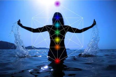 Silueta de persona en el agua con brazos extendidos, salpicando agua. Geometría sagrada y chakras visibles, indicando un posible segundo chakra bloqueado.