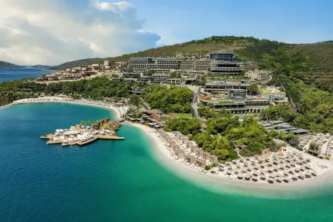 Luksusowy kurort nad turkusowym morzem, z plażą, pomostem i hotelami na zboczu wzgórza. Jedno z najlepszych miejsc na świecie.