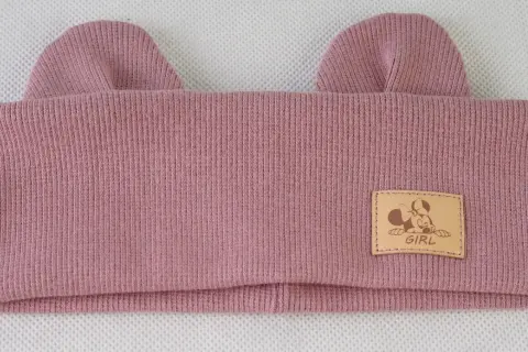 Różowa czapka z uszami myszy i naszywką z Myszką Minnie.