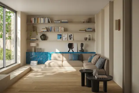 Ein heller Boden trifft auf eine warme, sandfarbene Wandfarbe. Ein gemütliches Wohnzimmer mit Bücherregalen, einem Sofa und einem großen Fenster.
