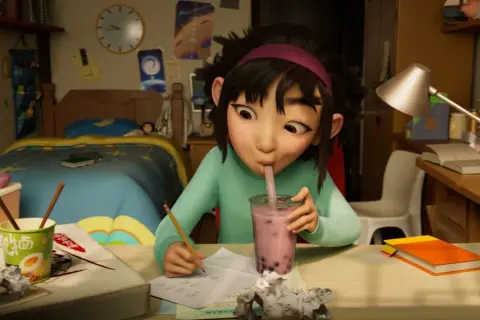 Dziewczynka pije bubble tea, siedząc przy biurku. Może to scena z bajek dla 4 latka na Netflixie.