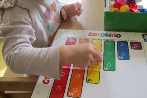 Ein Kind lernt im Kindergarten spielerisch Formen und Farben mit dem Spiel "Colorino".