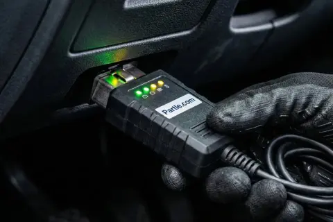 Rękawica podłącza urządzenie diagnostyczne do portu OBD. Wskaźniki LED świecą, sygnalizując gotowość do analizy parametrów, w tym kąta wyprzedzenia zapłonu.