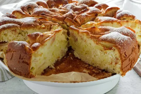 Wilgotne ciasto z jabłkami na oleju, posypane cukrem pudrem, prezentuje się apetycznie.
