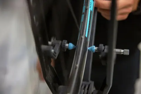 Fietsband met een slag uit wiel halen. Een blauwe dop op het ventiel, klaar voor reparatie.