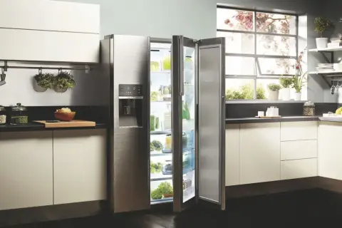 Cuisine moderne avec réfrigérateur ouvert, rempli de produits frais. L'inconvénient froid statique est évité grâce à une organisation optimale.