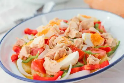 Ensalada campera con atún desmigado, huevo duro, tomate, pimiento y cebolla. Un plato fresco y completo.