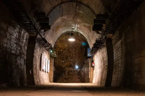Mroczny tunel w górach sowich, z odsłoniętymi elementami konstrukcyjnymi i oświetleniem.