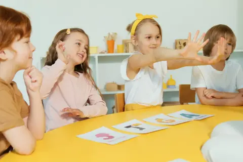 Dzieci uczą się liter na kartach. Czy żłobek podlega pod kuratorium? To pytanie nurtuje wielu rodziców, ale tu maluchy skupione są na nauce.