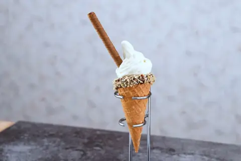 En mjukglass av vanlig glass, med strössel och en chokladpinne, serveras i ett krispigt våffelstrut.