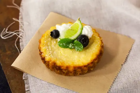 Deliciosa torta de ricota, decorada con arándanos, menta, crema y una rodaja de lima.