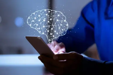 Dłoń trzyma smartfon, nad którym unosi się świetlisty mózg. Aplikacja pomaga zrozumieć, ile czasu się trzeźwieje.
