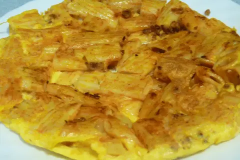 Tortilla de macarrones dorada y apetitosa, con trozos de pasta integrados en el huevo. ¡Un plato casero perfecto!