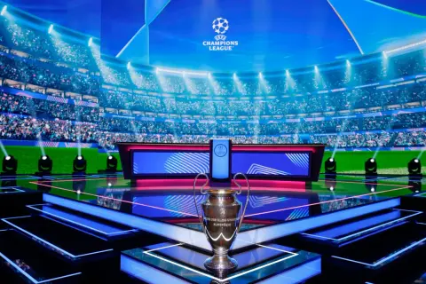 Trofeum Ligi Mistrzów na tle stadionu i studia. Już wkrótce kolejne mecze ligi mistrzów!