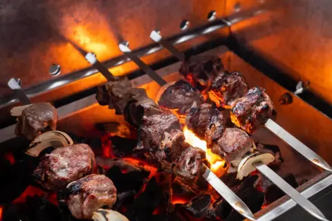 Fleischspieße mit Zwiebeln brutzeln über glühender Kohle. Perfekt, welches Fleisch zum Grillen!