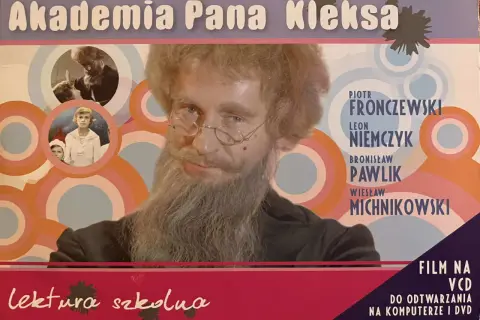 Piotr Fronczewski jako Pan Kleks w filmie "Akademia Pana Kleksa". Obok niego wizerunki dzieci i napisy.