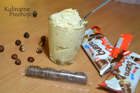 Kremowy deser o smaku Kinder Bueno, obok orzechy i batoniki. Idealny dla łasuchów, którzy uwielbiają słodkości.
