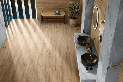 Baño moderno con suelo porcelánico imitando madera. Mueble de lavabo doble con lavabos sobre encimera y grifería negra.