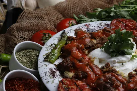 Würziges Gericht mit Hackfleisch, Tomaten und Paprika. Sumach-Verwendung zeigt sich in der rubinroten Gewürzmischung, die für Farbe und Aroma sorgt.