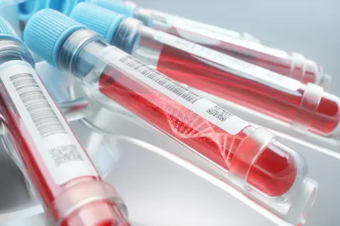 Blodprovsrör med rött blod och DNA-spiral. Kan användas för att identifiera blodgrupp.