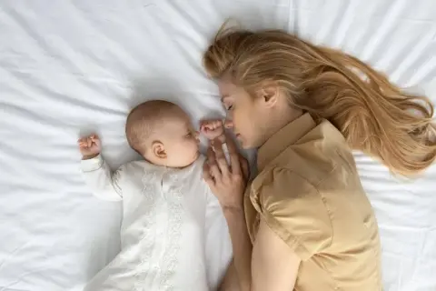 Madre e hijo duermen abrazados. Un momento de paz y conexión, esencial en el tratamiento post parto.