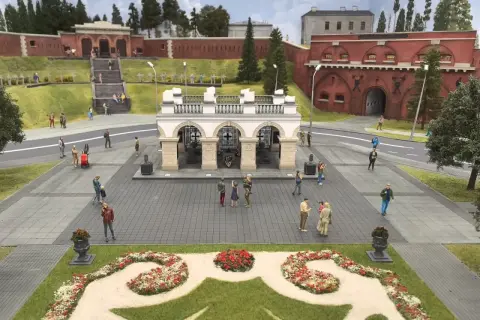 Miniaturowy park w Warszawie z ludzikami spacerującymi po placu przed bramą fortu.
