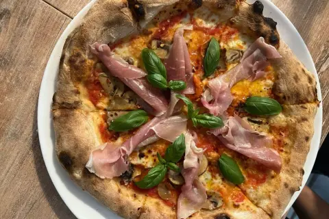 Pyszna pizza z szynką parmeńską i bazylią. Warto sprawdzić ceny w Chorwacji, bo takie smakołyki są warte swojej ceny!