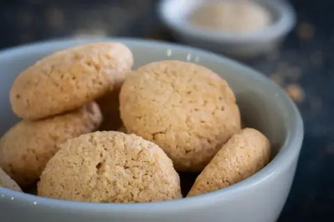 Kleine, goldbraune Amarettini in einer Schale, bereit zum Genießen. Ein einfaches amarettini rezept für süße Momente.