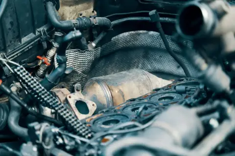Silnik samochodowy z widocznym elementem układu wydechowego, przypominającym katalizator lub dpf. Co to jest dpf?