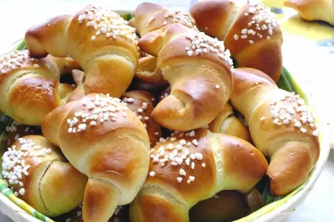 Koszyk pełen mięciutkich rogalików drożdżowych, posypanych cukrem. Idealne na śniadanie, zgodnie z prostym mięciutkie rogaliki drożdżowe przepis.