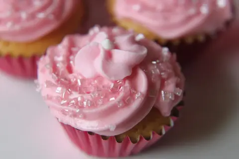 Rosa muffins med sockerströssel och fluffig frosting. Perfekt för en festlig stund.