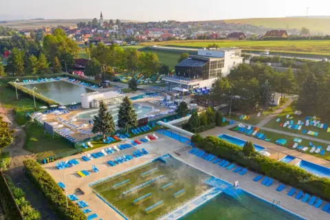 Kompleks basenów i wypoczynku z leżakami, idealny na wakacje. Sprawdź vrbov bungalow cennik.