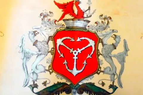 Herb Gdyni: czerwona tarcza z białym kotwicą, podtrzymywana przez dwa gryfy. Na górze czerwony gryf z koroną i kotwicą.